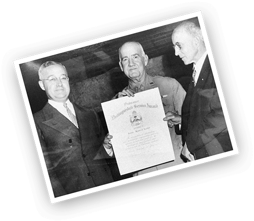 Photo of Battelle holding Ordnance Distinguished Service Award
