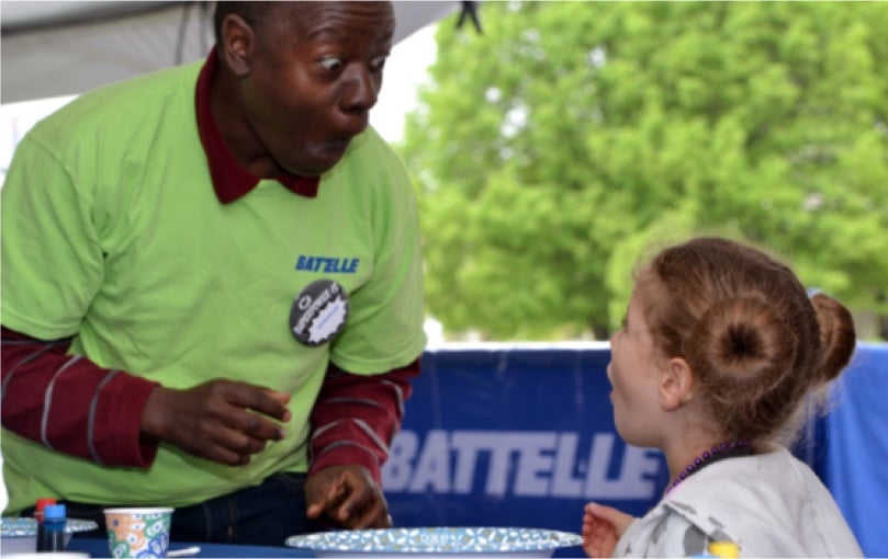 Photo: Battelle volunteer and child learning about STEM at COSI