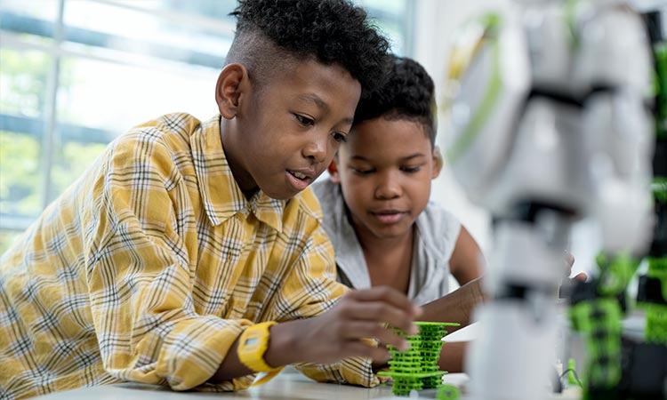 Photo: two black stem students working on a robotics project