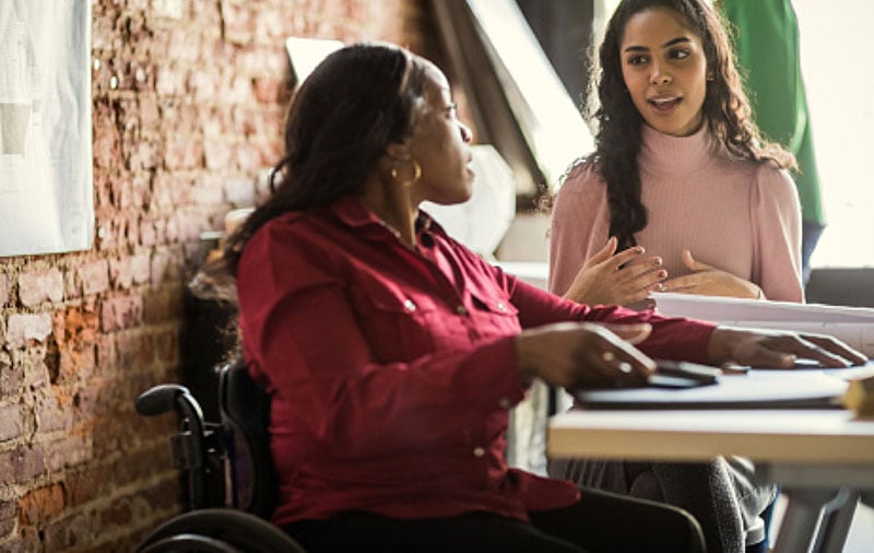 Photo: Battellle project manager in wheelchair working with a client