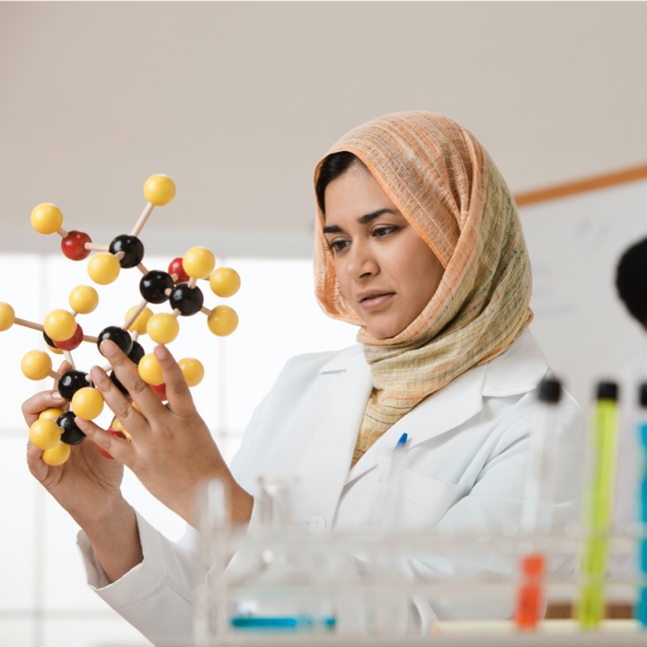Photo: Battelle omics researcher wearing a headscarve while holding a molecule.
