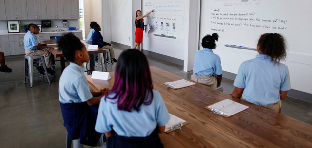 KIPP-class students watching a teacher at the board in a classroom