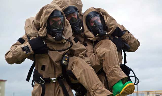 people in chem-bio suits carrying an injured person