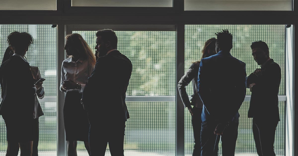 alt= business partners having a discussion at a conference