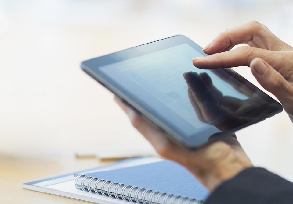 working-on-tablet alt: a person in a office working on a tablet