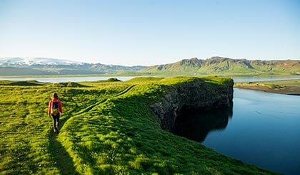 alt= a women walking along the edge of a cliff