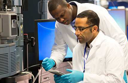 alt= two battelle scientist working on research together