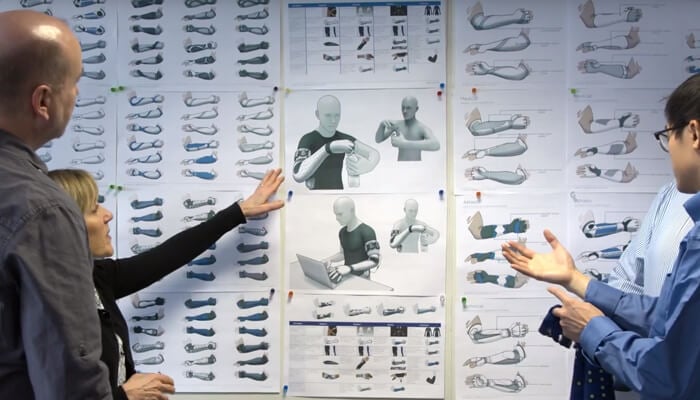 alt= three battelle engineers discussing the battelle neurosleeves capabilities