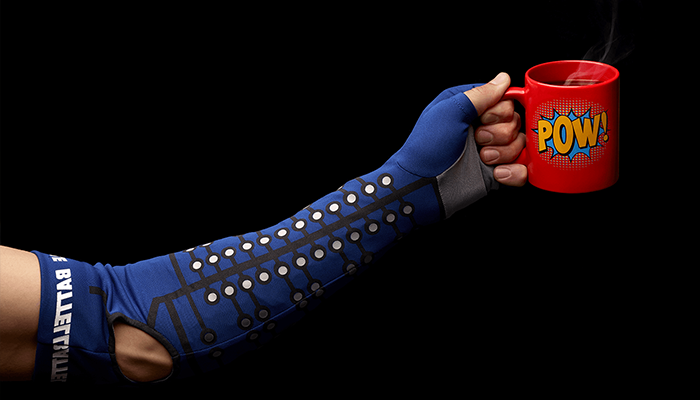 alt= close up a person wearing the battelle neuro sleeve and holding a coffee mug