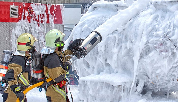 alt = firefighters putting out a fire with AFFF