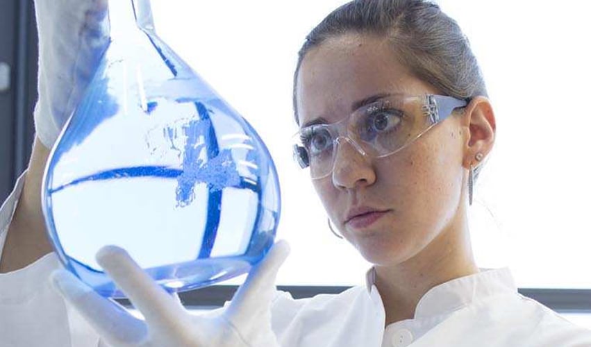alt= scientist looking at a sample in a beaker