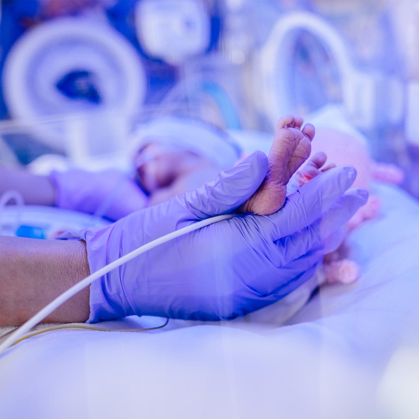 alt=a doctor holding a baby's foot in a aerosol delivery system