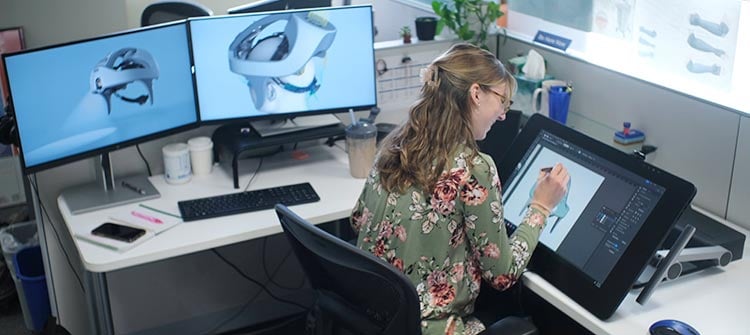 design-excellence-1 alt = an hcd engineer working a new design for a medical device at her desk