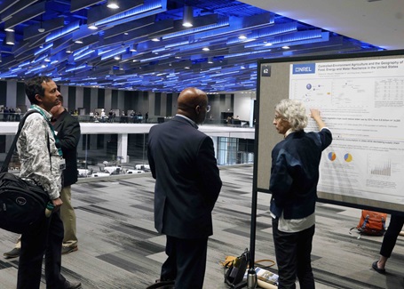 Photo: conference attendees examining a poster presentation at the battelle conference on innovations in climate resilience