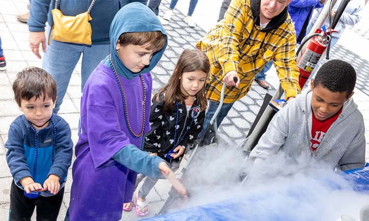 Photo: stem students engaging with the Battelle booth at the 2022 cosi science festival