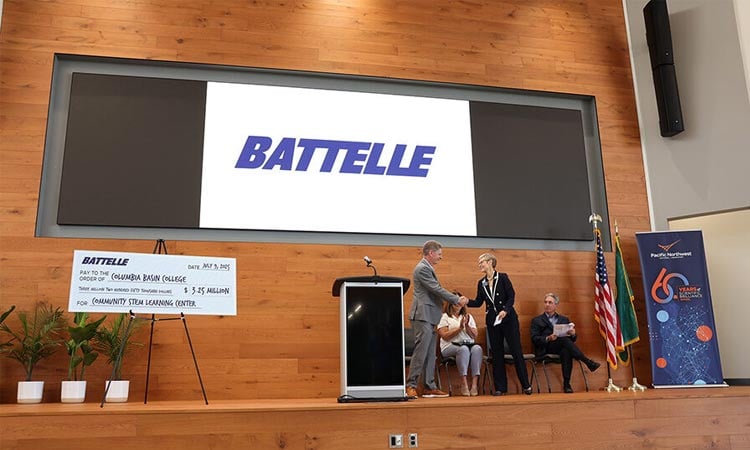 alt= battelle ceo and president lou von thaer presenting a $3.25 million check to the columbia basin college