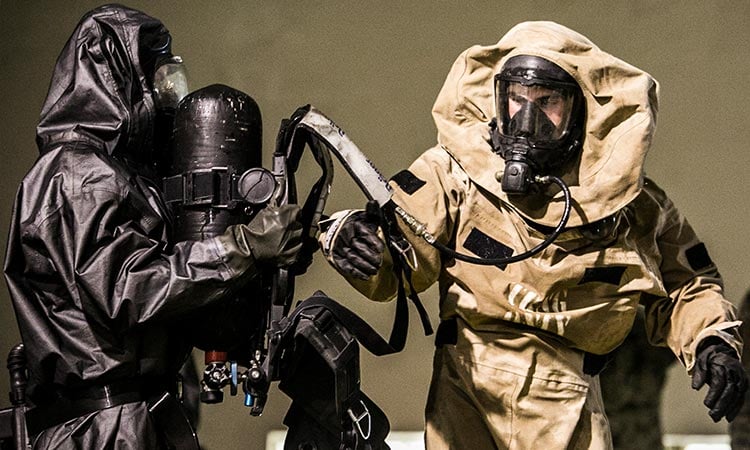 alt=two soldiers wearing protective cbrne gear