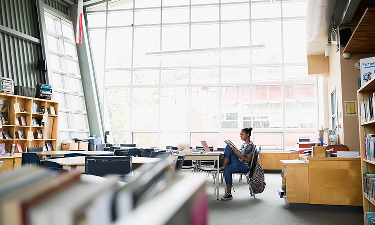 Photo: Woman reading book in library