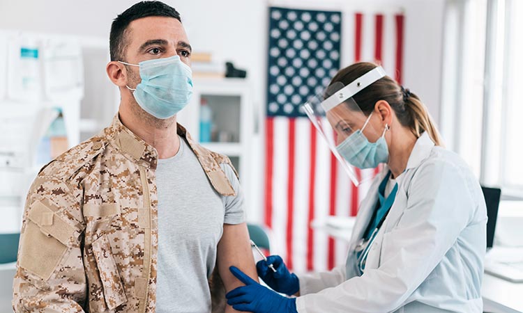 Photo: solider getting a vaccine from a medical professional