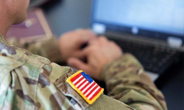 Photo: military personnel working on computer