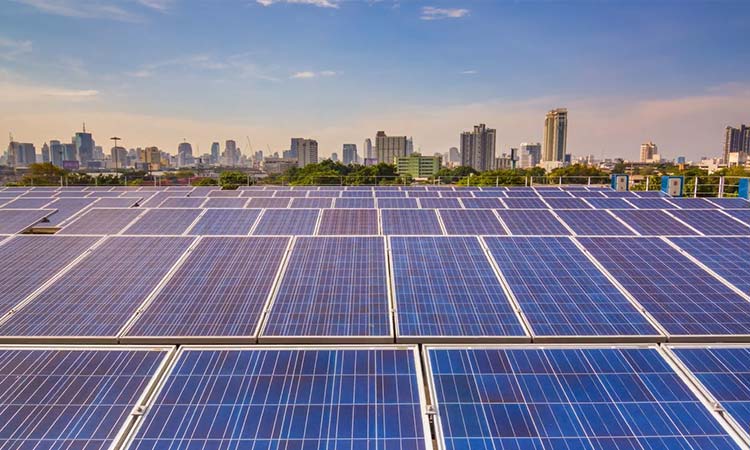 Photo rows of solar panels in front of a city skyline