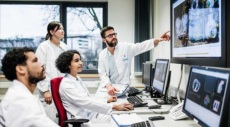 Photo: 4 doctors analyzing data in a lab