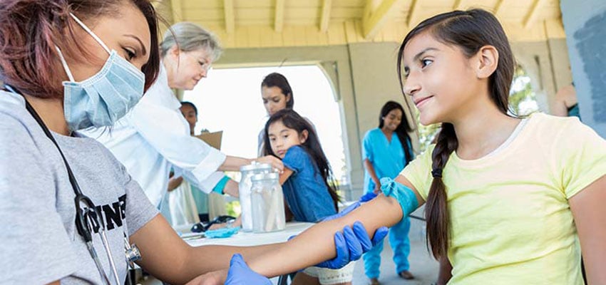 Photo: Public health worker administering a vaccine to a child