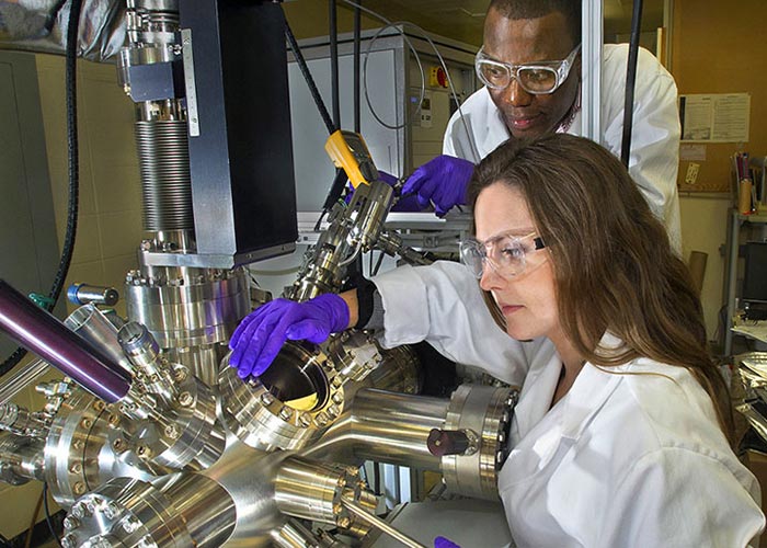 Photo: three scientists talking in a lab