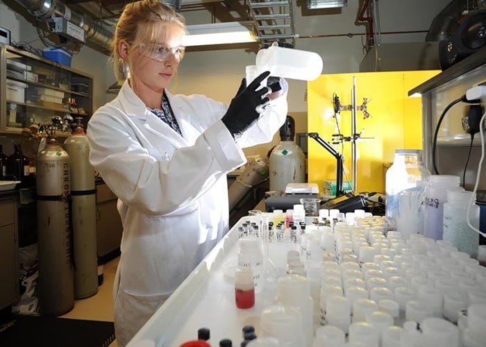 Photo: three scientists in a lab analyzing data