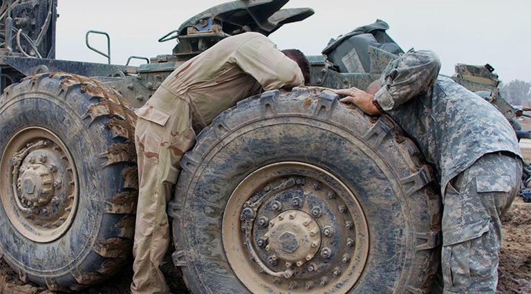 Photo: Armed Forces members repairing a military vehicle