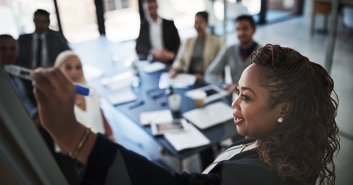Photo: Businesswoman presenting to team in office