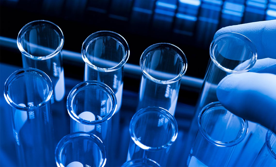 alt= close up of a medical device engineer picking up a test tube