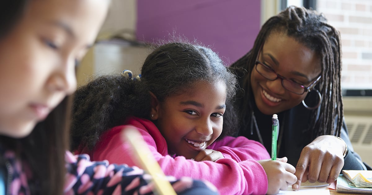 Photo: Teacher, and child doing work, smiling