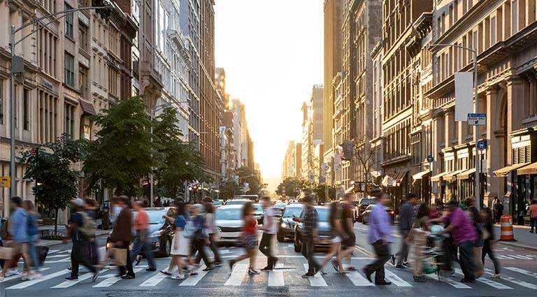 Photo: crowd of people walking across a crosswalk in a large city