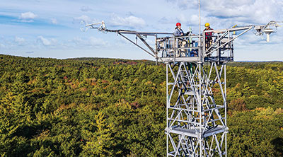 Photo: two neon researchers working in a tower