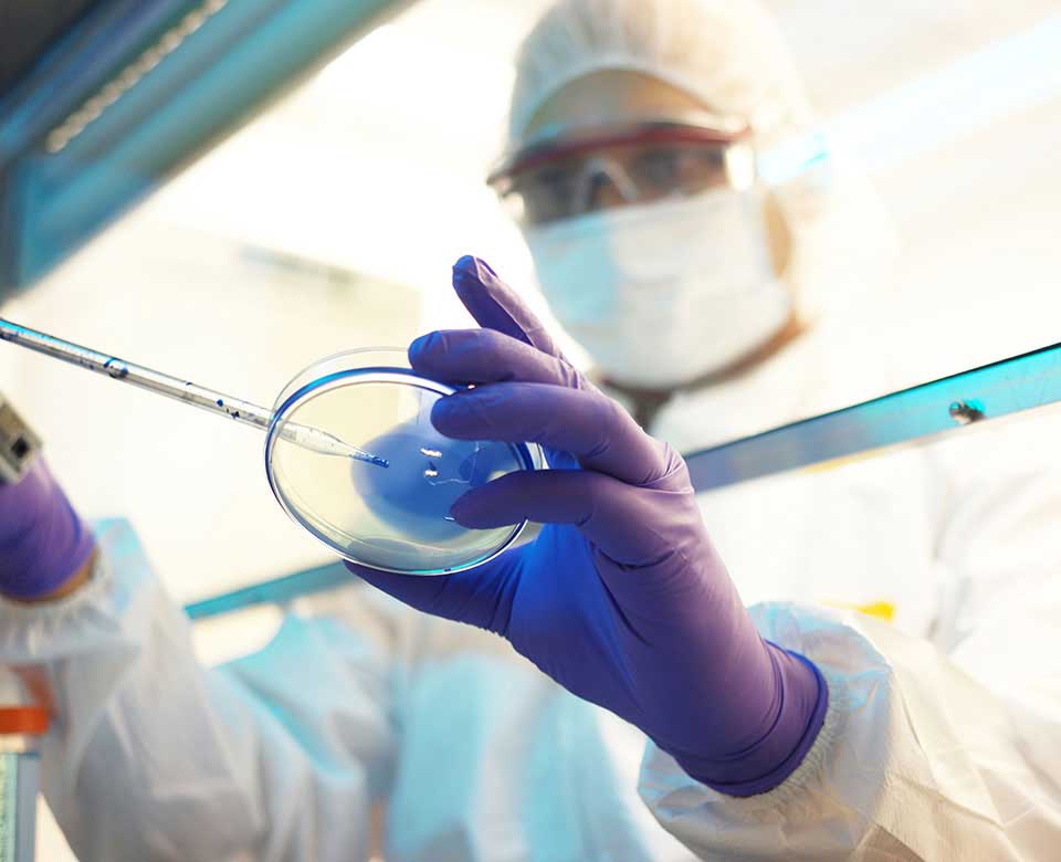 Photo: Battelle-trained researcher examining a virus sample