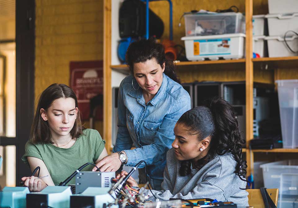 Photo: STEM Student working on engineering project with help from teacher