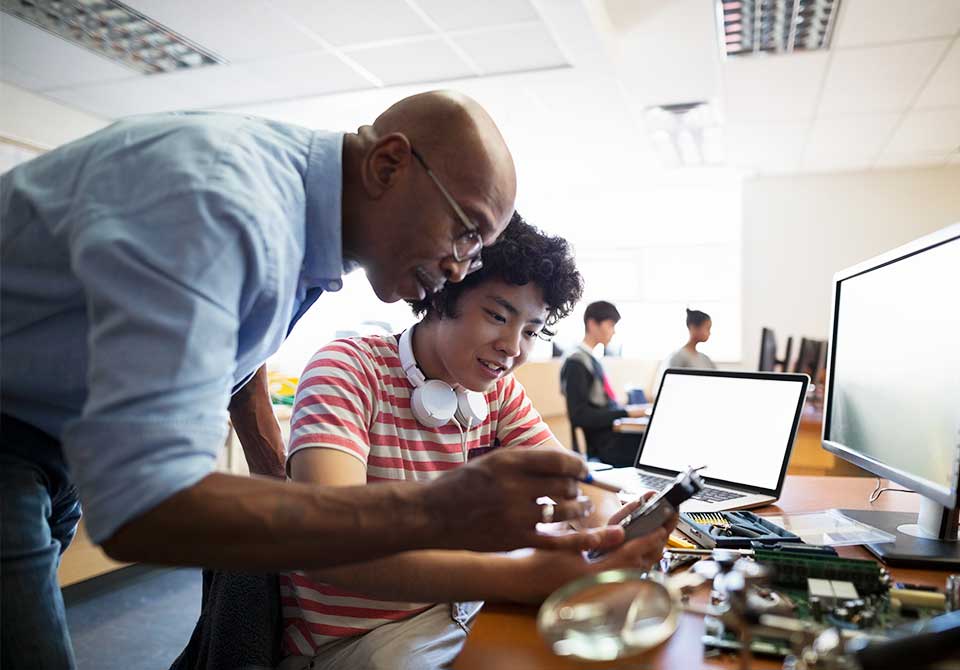 Photo: stem educator helping a students with engineering project