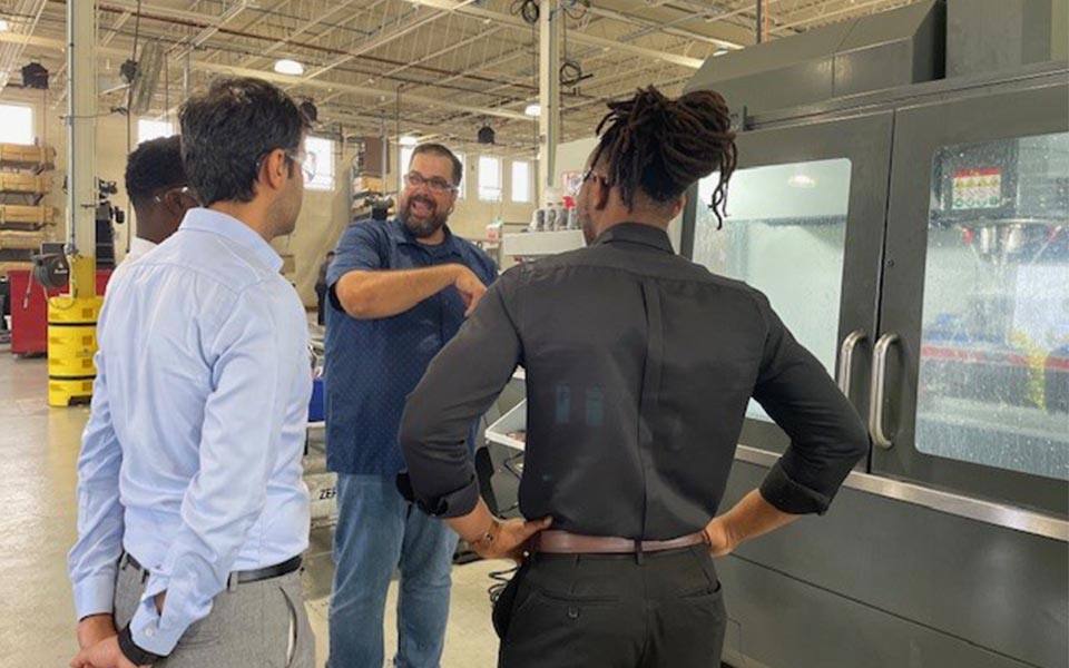 alt=teachers at lathe on a tour during an industry externship day
