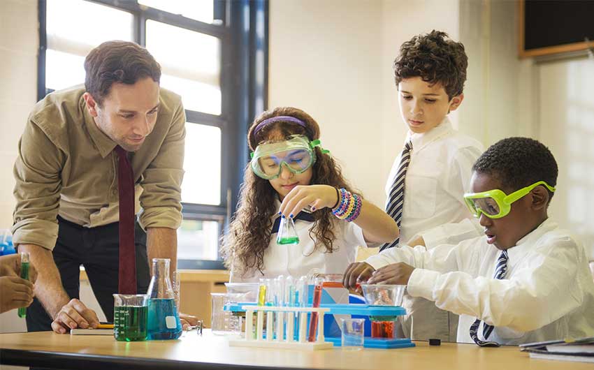 Photo: STEM educator helping students with a chemistry project
