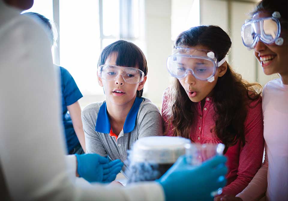 STEM Philanthropy Feature Photo: three stem students observing a chemistry project