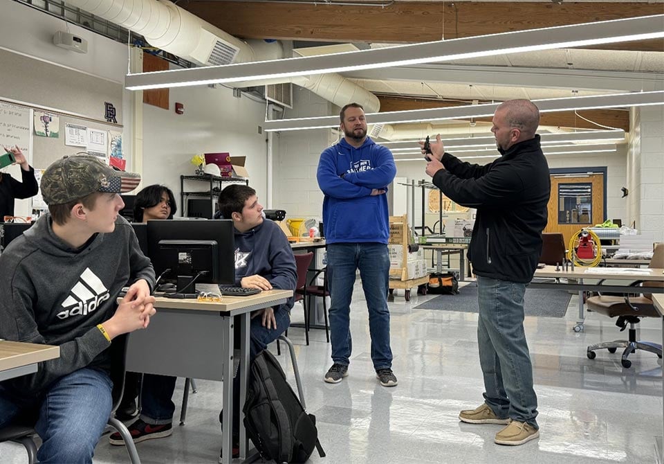alt= two stem teachers showing a demo of a technology in a classroom to their stem students