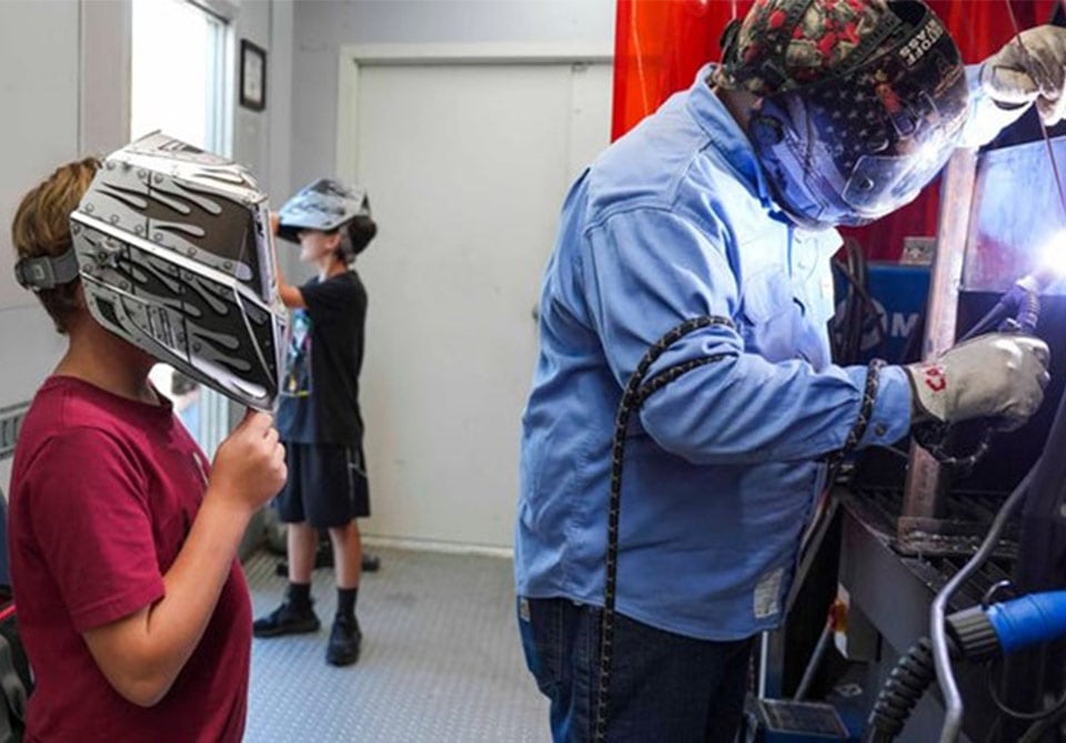 alt=teacher showing a stem student a demo