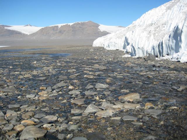Photo: Microbial mats (in the foreground with rocks) in the Canada ASPA (Antarctic Specially Protected Area), next to Canada Glacier, in the headwaters of Canada Stream. 