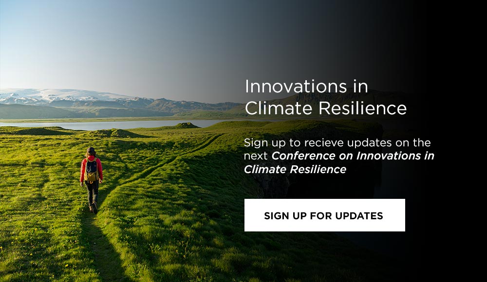 Photo: climate resilience scientist walking on a grassy hill 