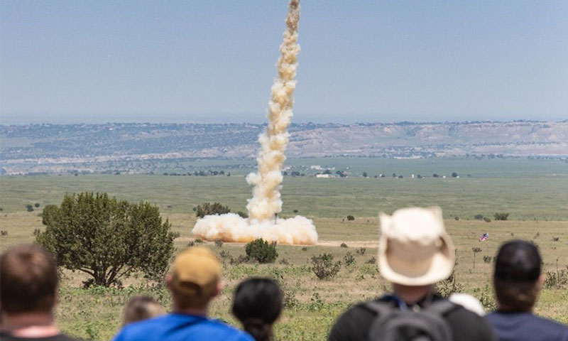 Photo: Students and educators watching a rocket take flight